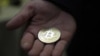 RUSSIA ECONOMY CRYPTOCURRENCY -- A visitor holds a Bitcoin (virtual currency) souvenir coin, during a webinar by Russian businessman, Orthodox activist and founder the Crypto exchange CryptoSterlingClub Alisa, German Sterligov at the main office of Crypt