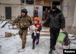 Полицейские эвакуируют из Бахмута 6-летнюю Арину. 31 января 2023 года. Фото: Reuters