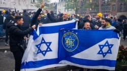 Supporters of Maccabi Tel Aviv hold flags at Dam square ahead of the Europa League football match between Ajax and Maccabi Tel Aviv, in Amsterdam on November 7, 2024. (Photo by Jeroen Jumelet / ANP / AFP) / NETHERLANDS OUT